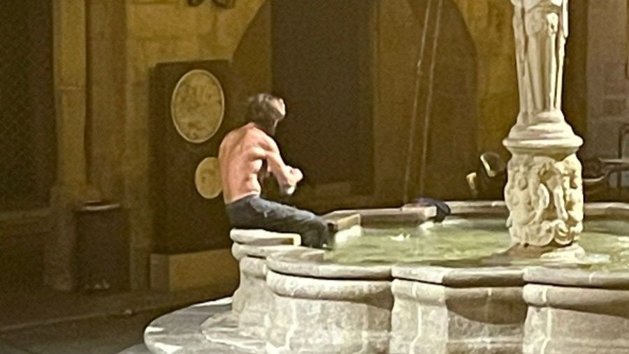 Un hombre se da un baño en la fuente de la Praza do Ferro de Ourense.