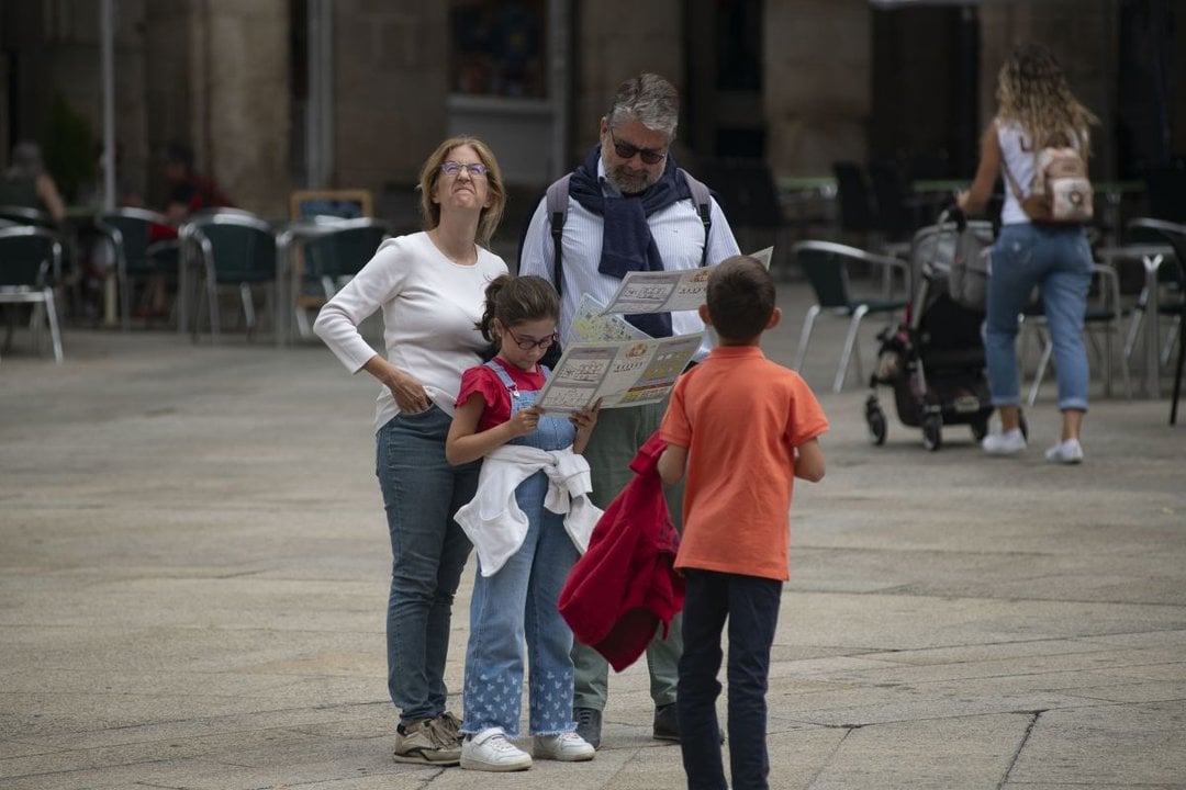 Una familia observa un mapa de la ciudad, ayer en la Praza Maior (Foto: Xesús Fariñas).