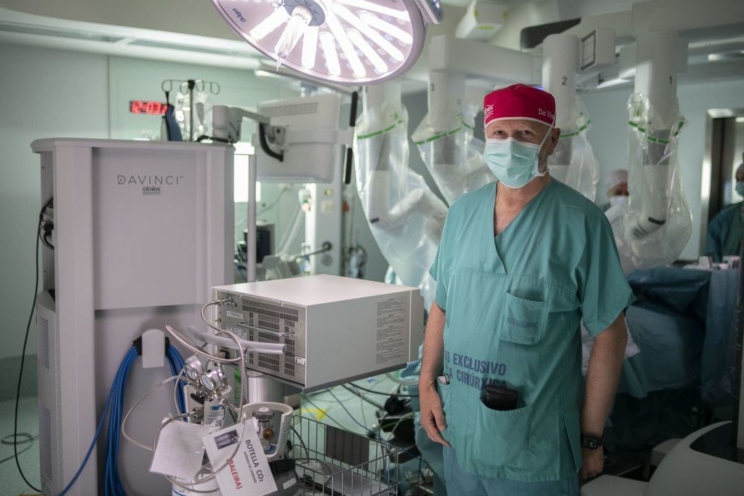 Manuel García, jefe de cirugía general del CHUO, con el robot Da Vinci de fondo.