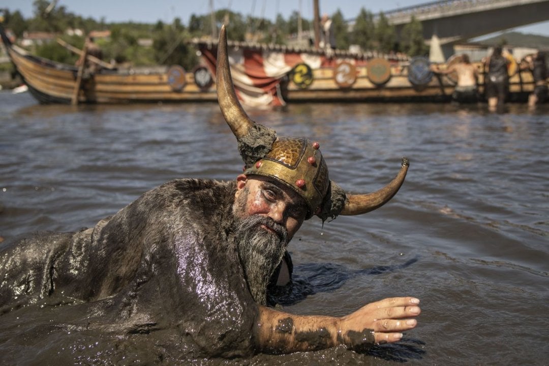 Un vikingo envuelto en barro tras la pelea  en Catoira.