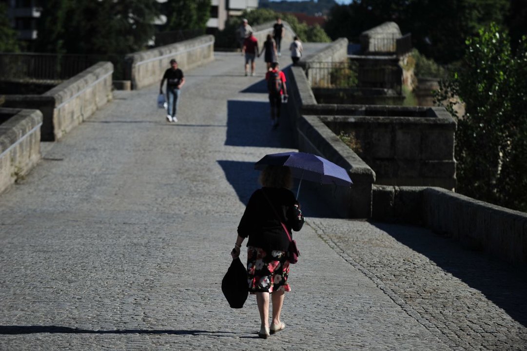 Una mujer se protege del sol con un paraguas, ayer en la ciudad de Ourense (Foto: José Paz).