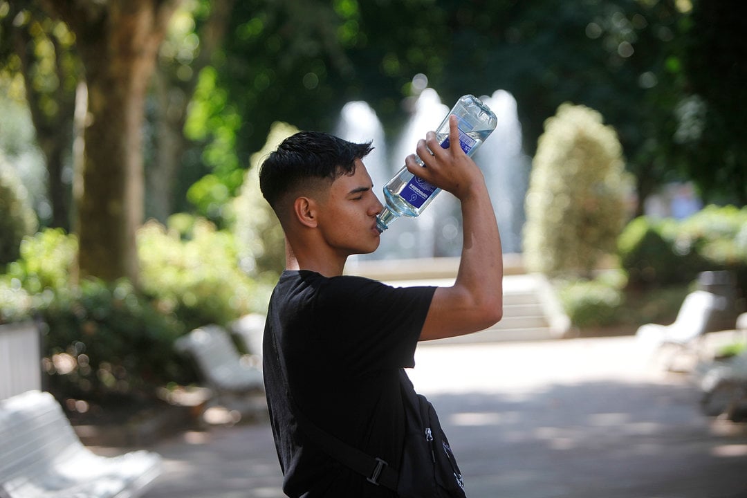 Un joven bebiendo para combatir la jornada de calor de este martes en Ourense. Foto: Miguel Ángel.