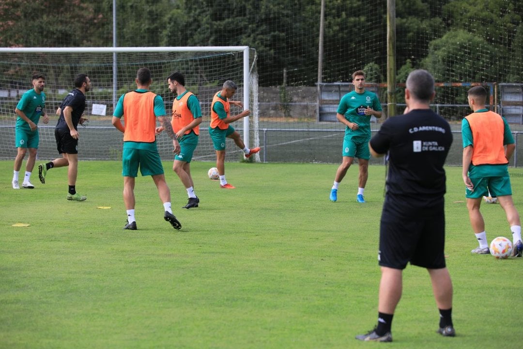 Los jugadores del Arenteiro se ejercitan en el campo A Regueiriña ante la atenta mirada de Javi Rey.