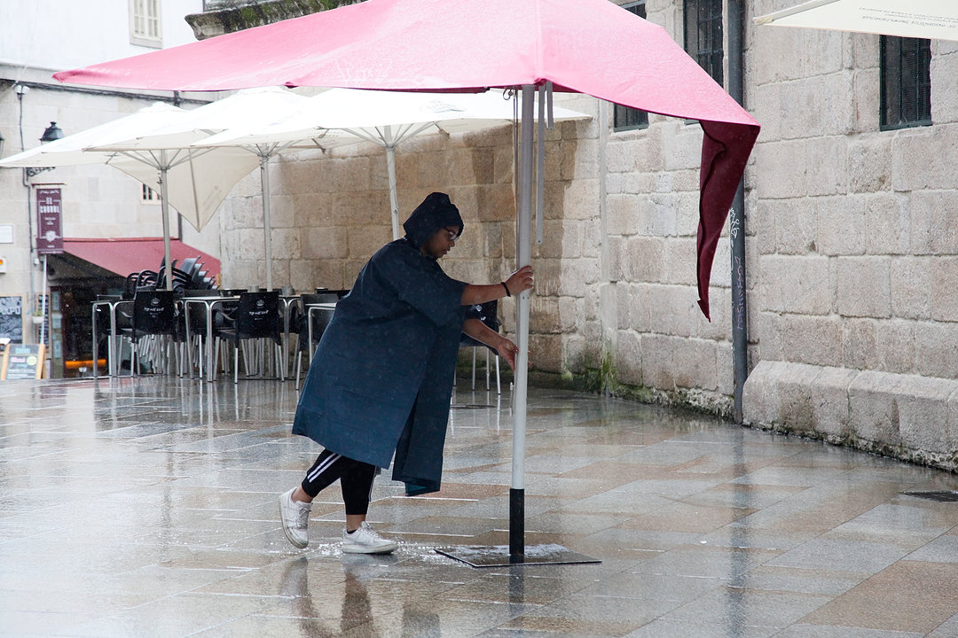 Una mujer guarda una sombrilla, ante las fuertes lluvias, en la zona de vinos de la ciudad.