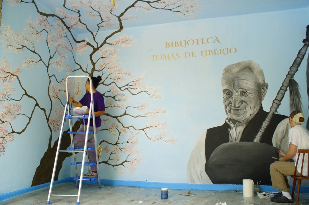 Alva López e Iraida López, durante la elaboración del mural en la biblioteca.