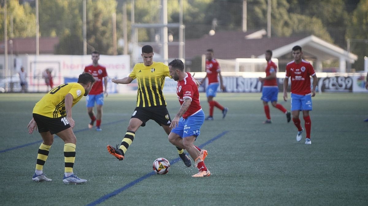 Varo, lateral de la UD Ourense, intenta colarse entre dos rivales del Rápido (Foto: Miguel Ángel).