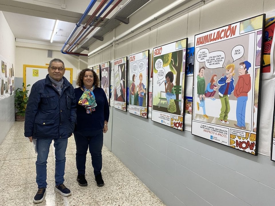 Orlando Saavedra y Amparo Quiroga posan junto a los paneles de la exposición en el centro.