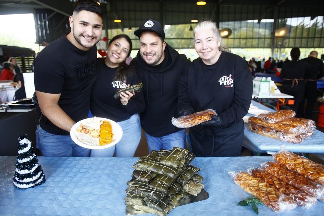 Venezolanos en Ourense muestran con la comida típica, en la Feria de la Chinita de 2022.