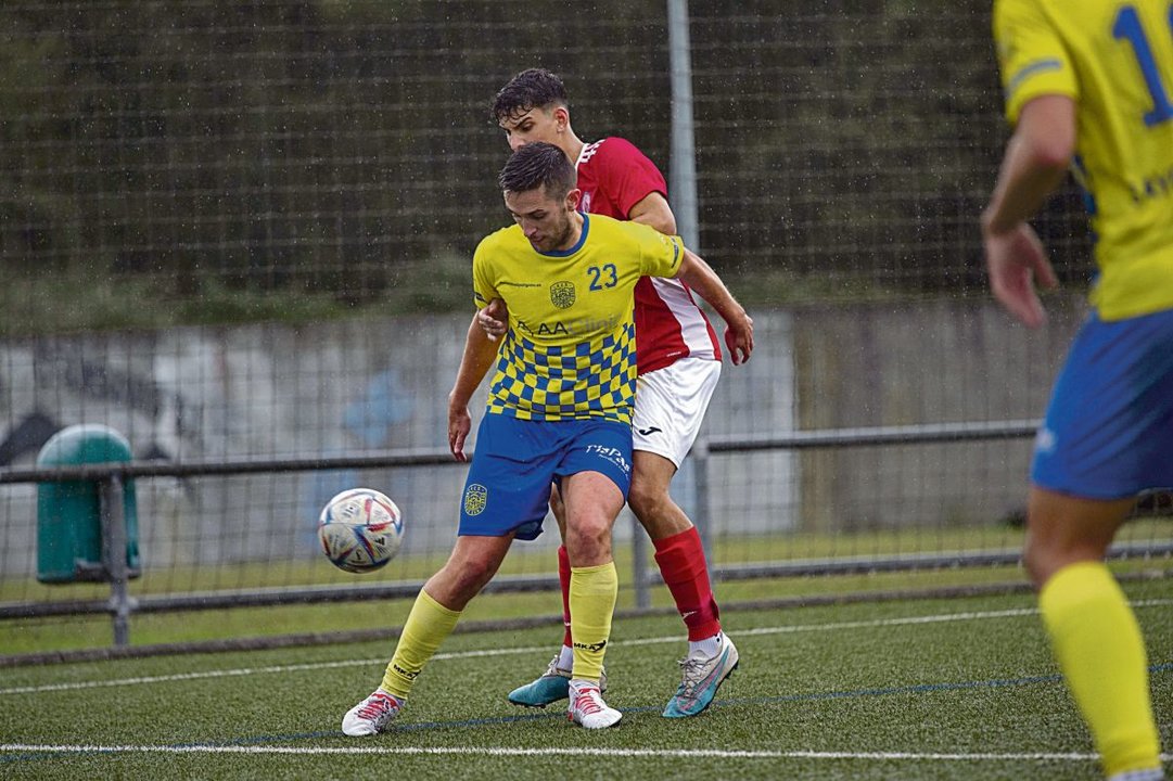 El jugador industrial Rubén Villa protege el balón presionado por Dosi, del Verín.