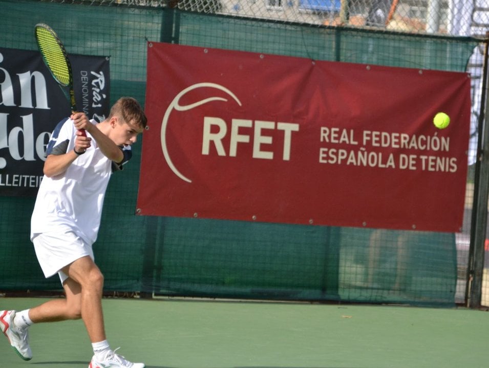 El joven tenista ourensano Izan Díaz Estévez conecta un revés en pleno partido de la competición nacional.