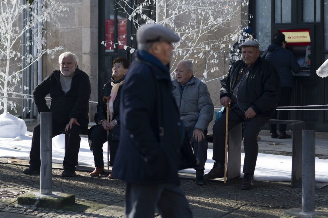 Un grupo de mayores sentados en un banco disfrutan de una mañana otoñal en Ourense.