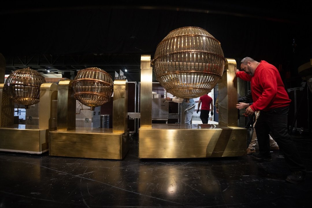 Personal de mantenimiento desplaza uno de los bombos del Sorteo Extraordinario de Lotería de Navidad 2023 en el Teatro Real (Foto: E.P.)
