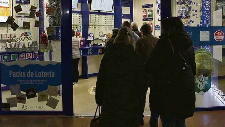 Los ciudadanos hacen cola para comprar un décimo en Loterías Anta.