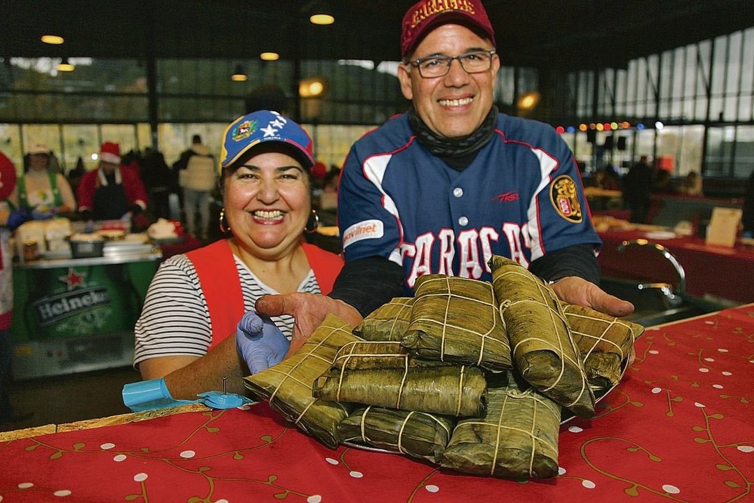 Una pareja de venezolanos muestra unas hallacas, comida típica de su país, en el Campo da Feira de Ourense (M. Ángel).