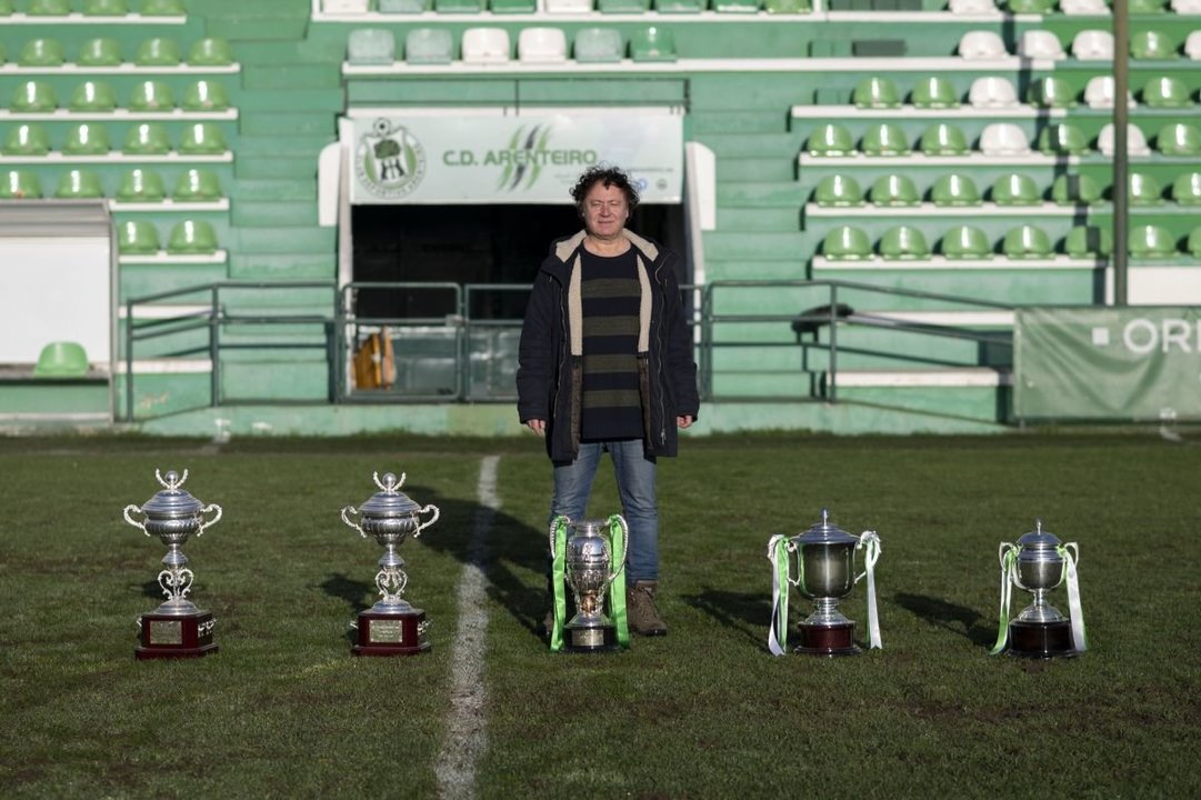 El actual vicepresidente del Arenteiro, Xan Pinal, sobre el césped del campo de Espiñedo, con los trofeos obtenidos por el club de O Carballiño en su etapata como máximo mandatario.