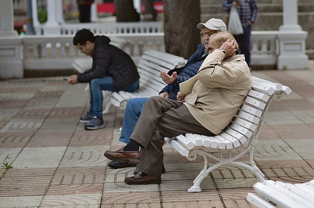 Dos hombres de avanzada edad charlan en el Parque de San Lázaro de la ciudad.