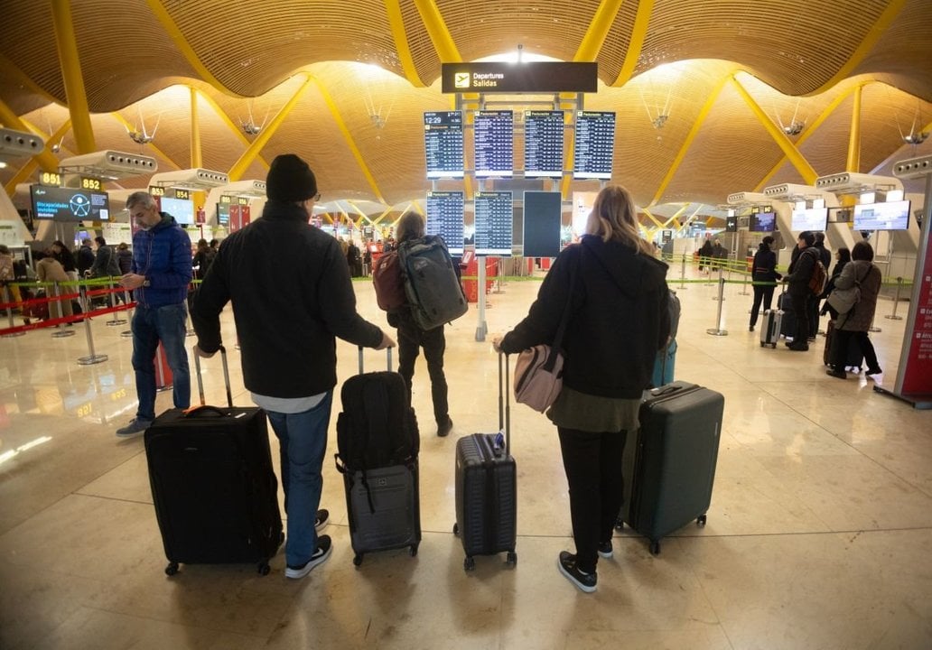 Un grupo de viajeros observa las pantallas informativas para conocer la hora de salida de su vuelo