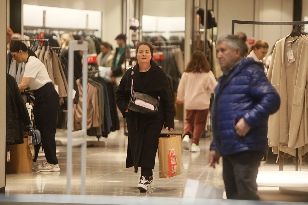 Una mujer sale de comprar en una tienda del Ponte Vella