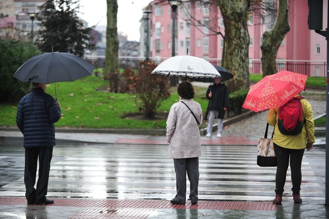 Viandantes con paraguas ayer en la ciudad.