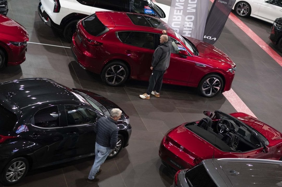 Clientes observando vehículos a la venta en el Salón del Automóvil de noviembre.