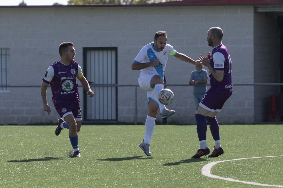 El sportinguista Martín Pérez golpea el balón en presencia de Jorge y Dani Chimpín. Foto: M. Pinal.