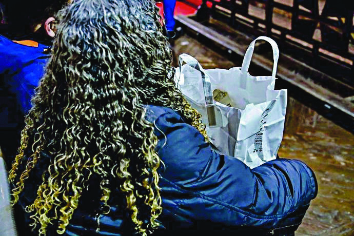 Una mujer recoge una bolsa de comida en una iglesia.