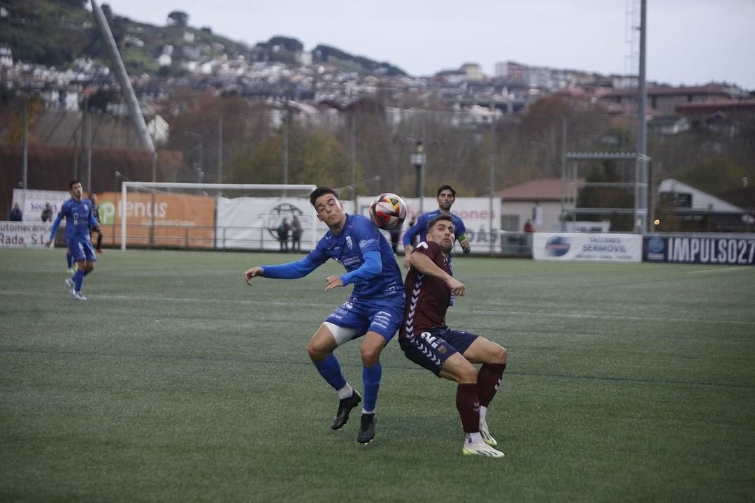 El delantero azulón Alberto Gil y el defensa granate Ángel Bastos luchan por llevarse una pelota en el partido de ida jugado en Oira.