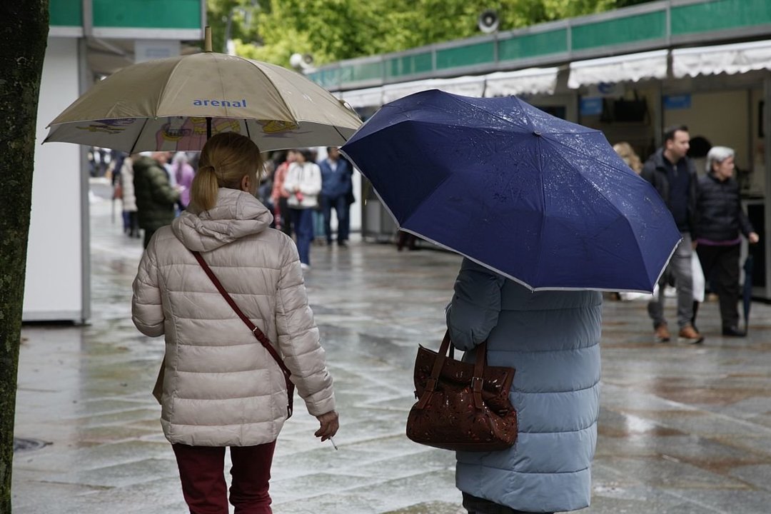 Dos mujeres, abrigadas bajo la lluvia ayer en la ciudad.