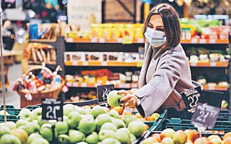 Una mujer compra fruta en un supermercado.