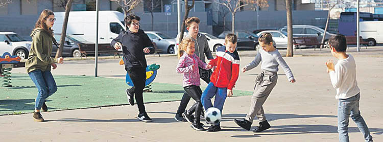 Un grupo de nenos e nenas xoga na rúa.