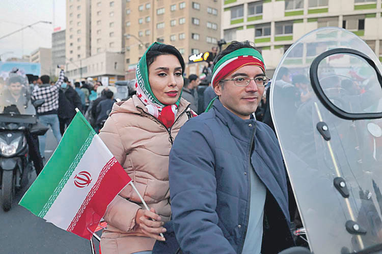Una mujer iráni, portando la bandera del país.