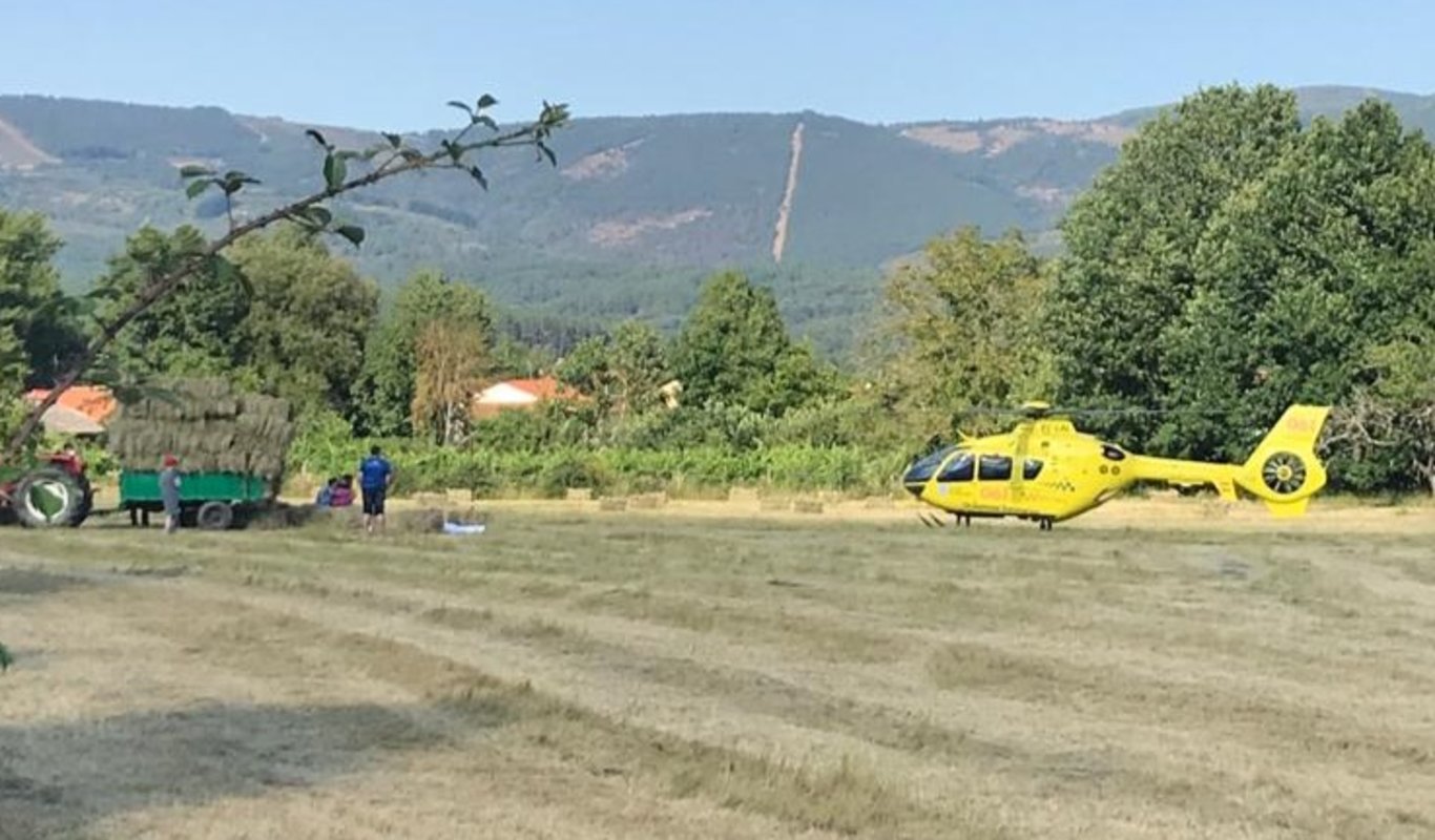 El helicóptero del 061, junto al tractor cargado de pacas, del que se cayó el fallecido.